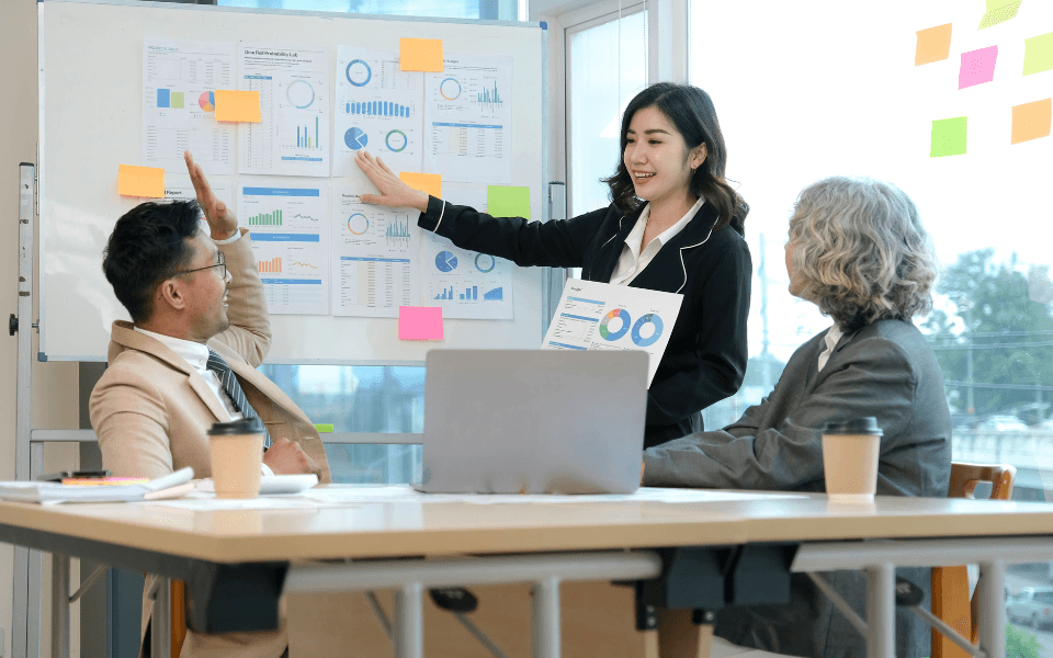 Equipe de profissionais analisando gráficos e checklists digitais, aplicando o Sistema Toyota de Produção (TPS) em empresas de serviços para otimizar processos e reduzir desperdícios.